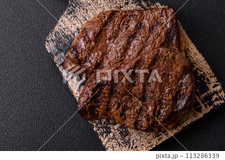 Fresh juicy delicious beef steak on a dark background 113286339