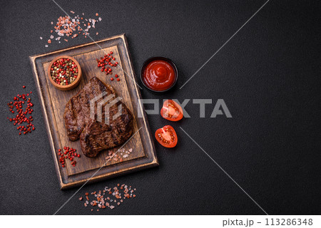 Fresh juicy delicious beef steak on a dark background 113286348