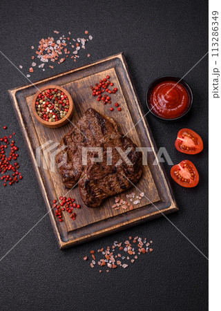Fresh juicy delicious beef steak on a dark background 113286349