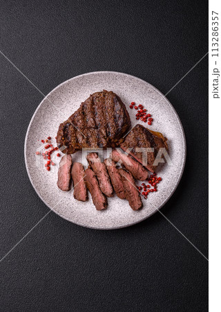 Fresh juicy delicious beef steak on a dark background 113286357
