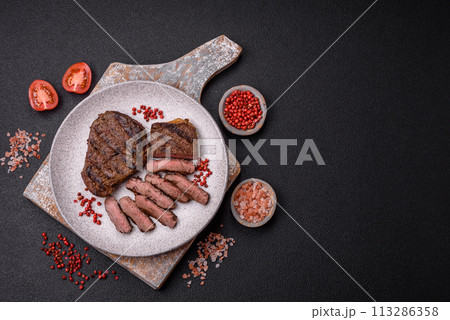 Fresh juicy delicious beef steak on a dark background 113286358