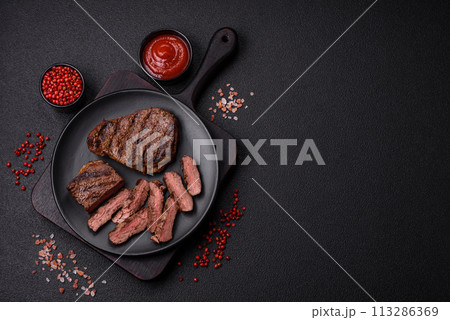 Fresh juicy delicious beef steak on a dark background 113286369