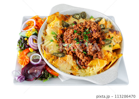 Mexican corn and vegetable salad with cheese and nachos chips in a white dish. Mexican food concept. On a white isolated background. 113286470