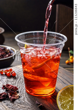 Hibiscus tea pouring. Herbal tea made from crimson calyces of roselle flower Hibiscus tea pouring. Herbal tea made from crimson calyces of roselle flower 113286643