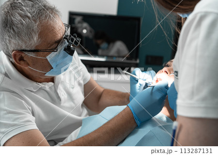 A dental assistant not only supports him in the treatment process, but also takes care of the patient's comfort, creating an atmosphere of trust and support. The teamwork of the doctor and assistant 113287131