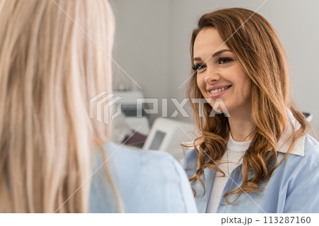 Personal approach: A woman is consulted by a professional cosmetologist who considers the individual needs of the client and provides recommendations for achieving perfect care. Personal approach: A woman is consulted by a professional cosmetologist who considers the individual needs of the client and provides recommendations for achieving perfect care. 113287160