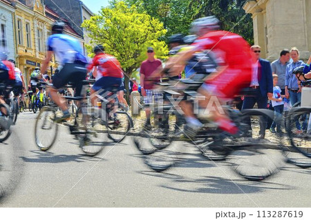Abstract arty background: motion blur of bicycle racers competing on city streets. Tour of cycling. Blurry background sport with cyclists 113287619
