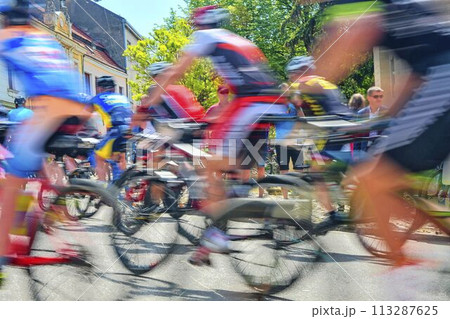 Abstract arty background: motion blur of bicycle racers competing on city streets. Tour of cycling. Blurry background sport with cyclists Abstract arty background: motion blur of bicycle racers competing on city streets. Tour of cycling. Blurry background sport with cyclists 113287625