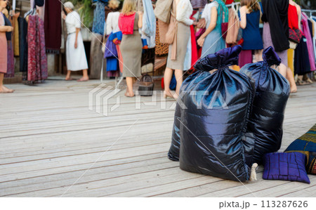 Large pile of garbage and textile waste in black bags for recycling, background and copyspace 113287626