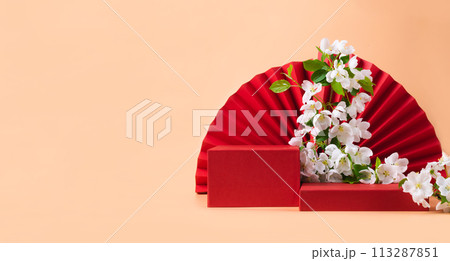 Red podium paper oriental fan flowering branch with buds pink pastel background 113287851