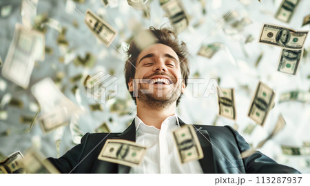An enthusiastic young man surrounded by a whirlwind of falling dollar bills symbolizing financial success, prosperity and joy of wealth. The joy of financial success An enthusiastic young man surrounded by a whirlwind of falling dollar bills symbolizing financial success, prosperity and joy of wealth. The joy of financial success 113287937