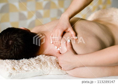 Massage Therapy: Man Rests Face Down on Plush Couch 113289147