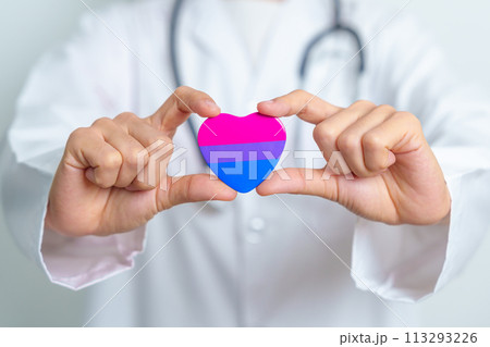 Bisexuality Celebrate Day and LGBT pride month,  LGBTQ+ or LGBTQIA+ concept. Doctor holding purple, pink and blue heart shape for Lesbian, Gay, Bisexual, Transgender, Queer and Pansexual community 113293226