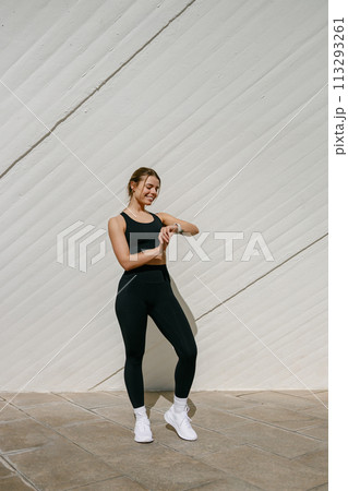 Young athlete woman looking at smartwatch and counting calories burned. Healthy life concept Young athlete woman looking at smartwatch and counting calories burned. Healthy life concept 113293261