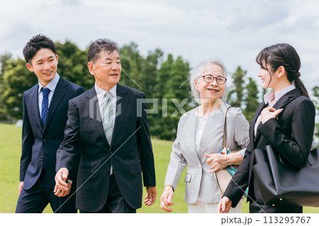 公園を歩くスーツ姿のシニア世代とZ世代のビジネスマンとビジネスウーマン 113295767