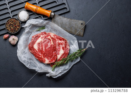 Raw ribeye steaks with savory spices Raw ribeye steaks with savory spices 113296788