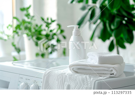 Stack of clean towels on modern washing machine with blurred background. The towels showcasing their soft and fluffy 113297335