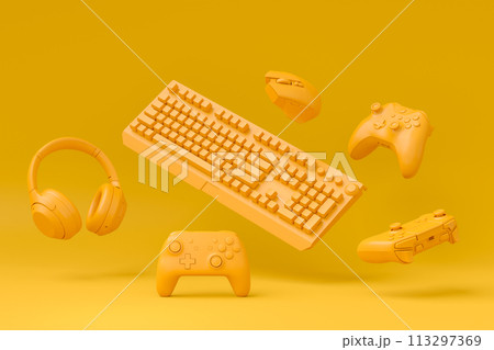 Modern home office setup featuring keyboard, gaming controllers and headphones 113297369