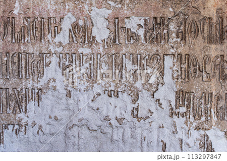 Ancient religious inscriptions on a dilapidated stone wall. Background, Texture for Design. High quality photo 113297847