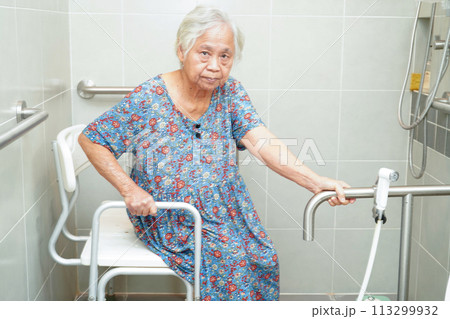 Asian elderly old woman patient use toilet support rail in bathroom, handrail safety grab bar, security in nursing hospital. 113299932