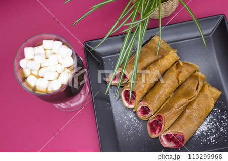Sumptuous Hot Chocolate and Berry-Filled Crepes on a Vivid Pink Backdrop 113299968