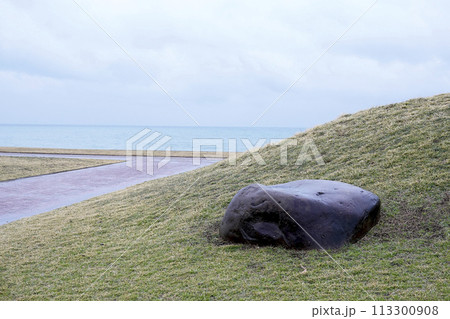 海沿いの公園に設置されたベンチのような石 113300908