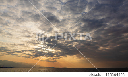 夕方の空に沈んでいく夕陽と、たくさんの雲 夕方の空に沈んでいく夕陽と、たくさんの雲 113304463
