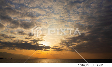 夕方の空に沈んでいく夕陽と、たくさんの雲 夕方の空に沈んでいく夕陽と、たくさんの雲 113304505