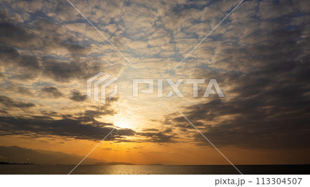 夕方の空に沈んでいく夕陽と、たくさんの雲 夕方の空に沈んでいく夕陽と、たくさんの雲 113304507