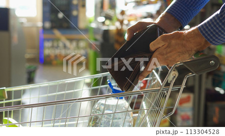 A grocery check in the hands of an elderly man A grocery check in the hands of an elderly man 113304528