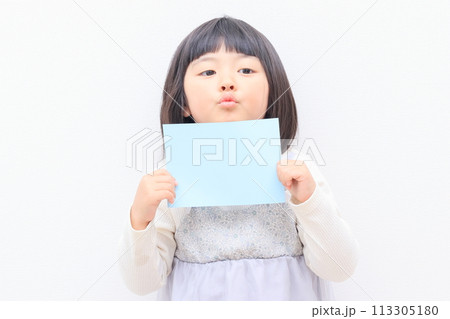 コピースペース用の紙を持った3歳の女の子 113305180