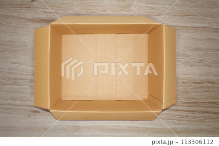 Opened cardboard box, top view, on wooden floor. Opened cardboard box, top view, on wooden floor. 113306112