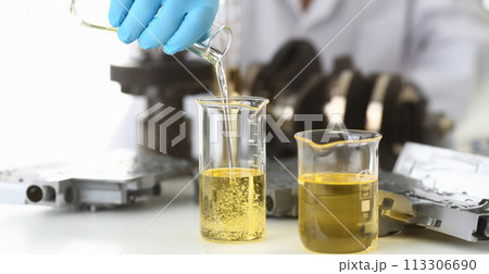 Male hands in protective gloves hold test tube 113306690