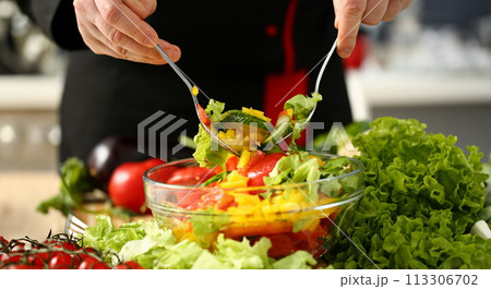 Cook holds fork in hand and mixes Cook holds fork in hand and mixes 113306702