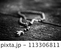 Rosary on an old wooden table illuminated by the sun 113306811