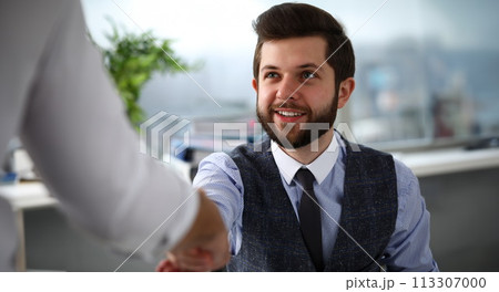 Man in suit and tie give hand as hello in office 113307000