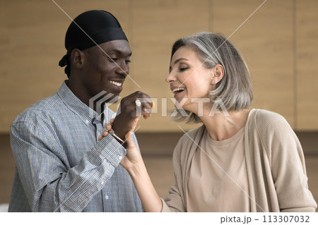 Happy multiethnic mature couple enjoy romantic date in the kitchen 113307032