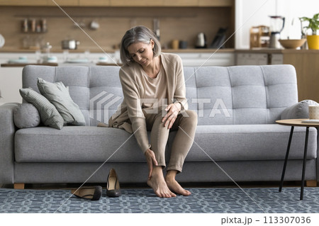 Woman took off shoes, touch feet, feeling pain after working Woman took off shoes, touch feet, feeling pain after working 113307036