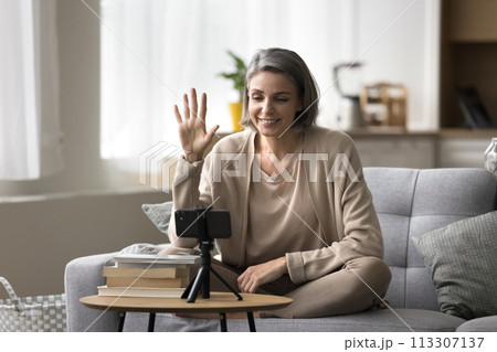 Smiling female vlogger recording videovlog using smartphone camera Smiling female vlogger recording videovlog using smartphone camera 113307137