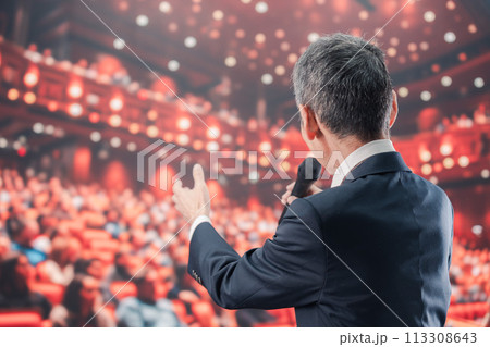 大勢の聴衆の前で話す男性 113308643
