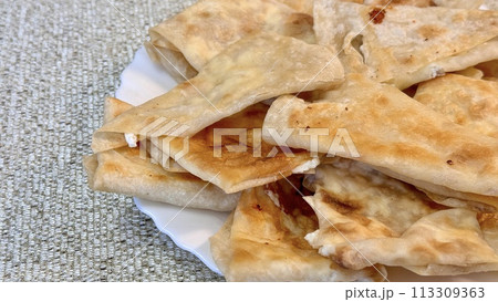 Fried pancakes-envelopes with cottage cheese, in form of envelopes in pita bread on white plate on table against background of a tablecloth 113309363