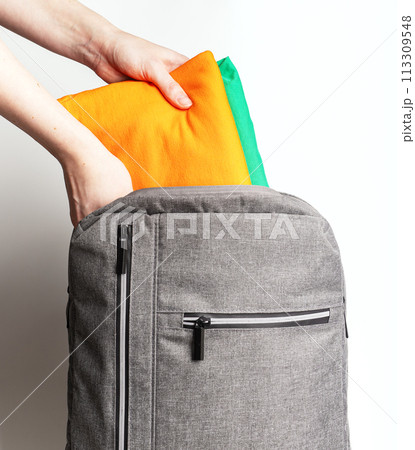Hands packing clothes, garments into backpack, travel bag 113309548