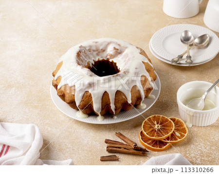 Pumpkin bundt cake drizzled with powdered sugar glaze on a plate Pumpkin bundt cake drizzled with powdered sugar glaze on a plate 113310266