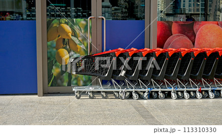 Row of shopping carts on summer street near store Row of shopping carts on summer street near store 113310330