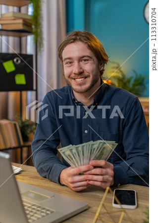 Rich businessman guy holding fan of cash money dollar banknotes showing thumbs up online income Rich businessman guy holding fan of cash money dollar banknotes showing thumbs up online income 113310704
