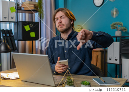 businessman using smartphone at home office showing thumbs down sign gesture dislike disapproval businessman using smartphone at home office showing thumbs down sign gesture dislike disapproval 113310731