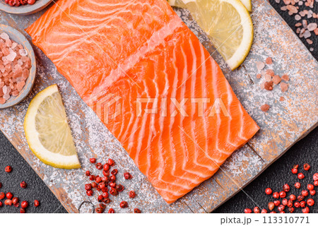 Fresh raw salmon steak with spices and herbs prepared for grilled baking 113310771
