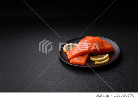 Fresh raw salmon steak with spices and herbs prepared for grilled baking Fresh raw salmon steak with spices and herbs prepared for grilled baking 113310776