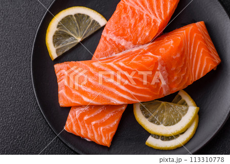 Fresh raw salmon steak with spices and herbs prepared for grilled baking 113310778