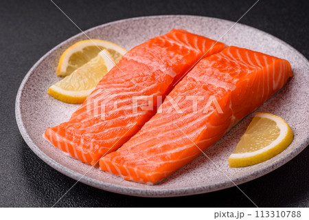 Fresh raw salmon steak with spices and herbs prepared for grilled baking Fresh raw salmon steak with spices and herbs prepared for grilled baking 113310788